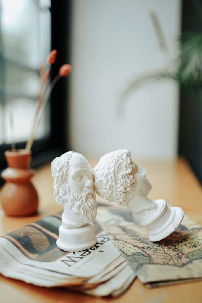 a couple of white busturines sitting on top of a wooden table